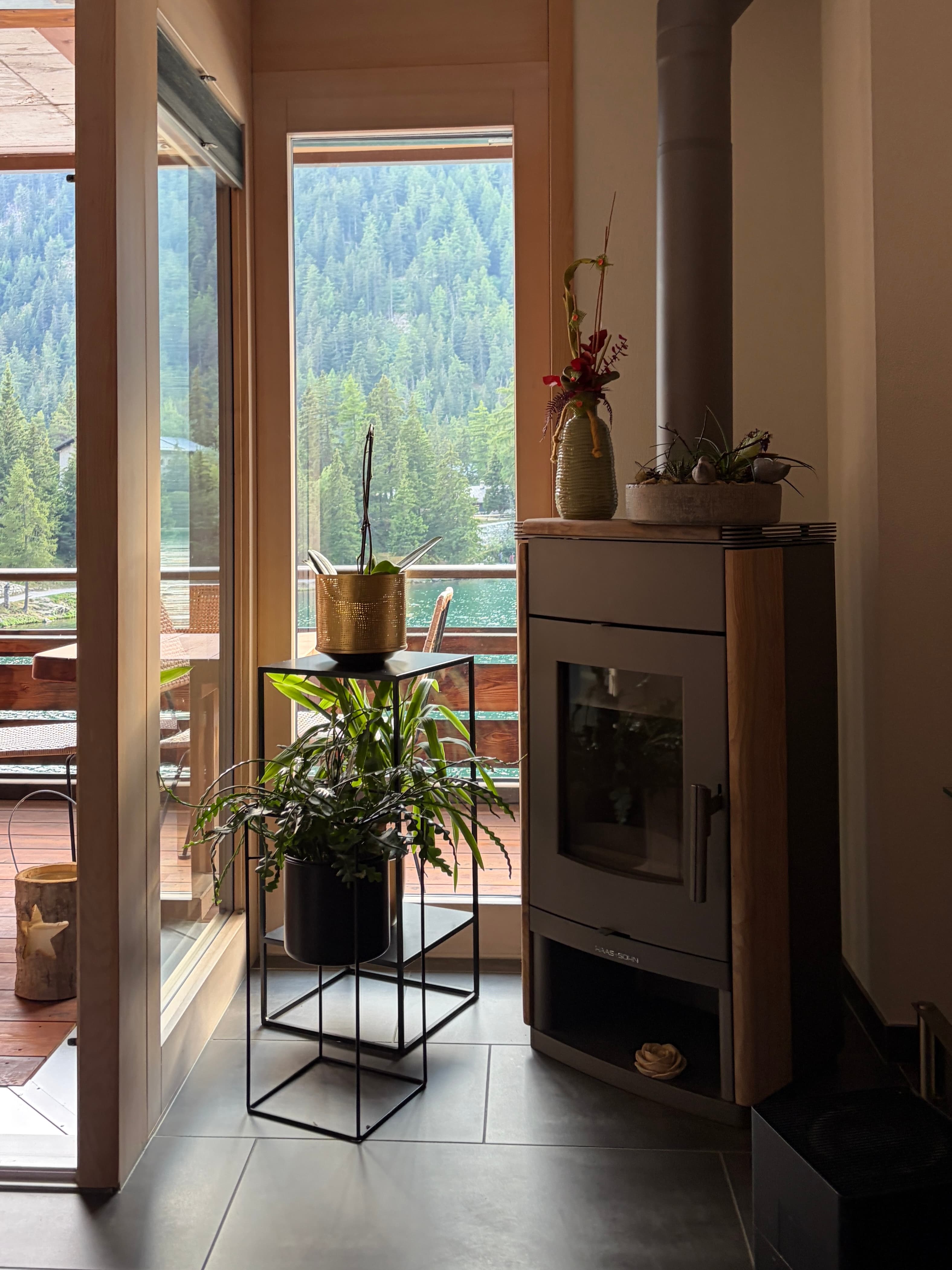 Fireplace glow inside The Alpine Nest, with mountain views beyond the window